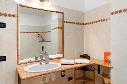 a bathroom with a sink and a mirror at Vallelaghi Escape in Terlago