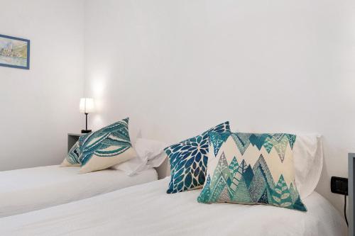a bedroom with two beds with blue and white pillows at Vallelaghi Escape in Terlago