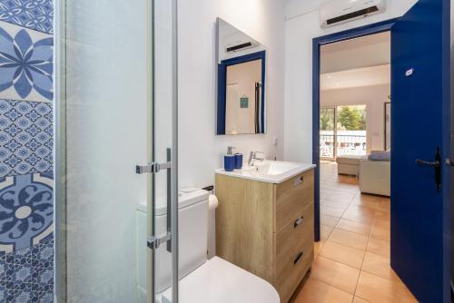 a bathroom with a toilet and a sink and a mirror at La caseta de Sa Riera in Begur