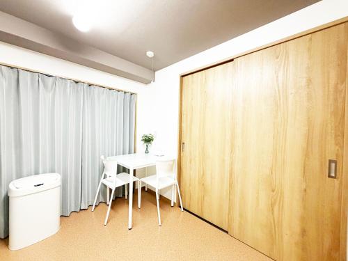 a room with a table and chairs and a sliding door at 花乃郷 川口 駅徒歩5分 上野 秋葉原 東京直通 池袋 新宿20分圏内 WiFi付き 洋室 温泉施設近く in Kawaguchi