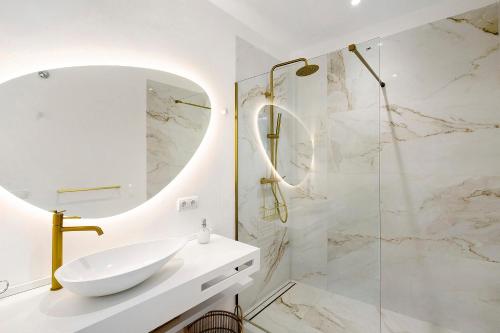 a white bathroom with a sink and a mirror at Blava in Begur