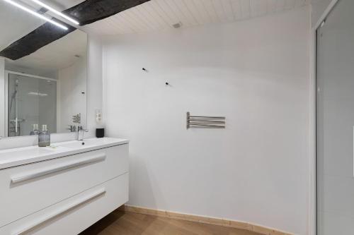 a white bathroom with a sink and a mirror at L'Ancrage - Maison 17è - Port in Camaret-sur-Mer