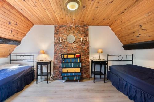 two beds in a room with a brick wall at L'Ancrage - Maison 17è - Port in Camaret-sur-Mer