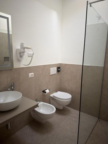 a bathroom with a toilet and a sink and a shower at Hotel Merloni in Grandola ed Uniti