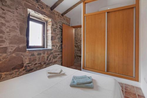 a room with a bed and a wooden cabinet at Recanto d'Aldeia in Alcoutim