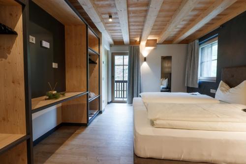 a hotel room with two beds and a desk at Chalet Ice Villa Genf Spa - Relax in Livigno