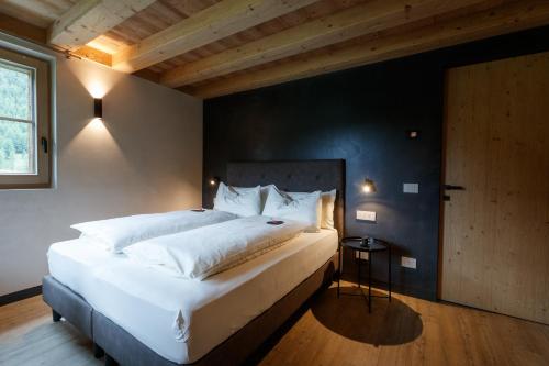 a bedroom with a large white bed and a window at Sun Villa Genf Spa - Relax in Livigno