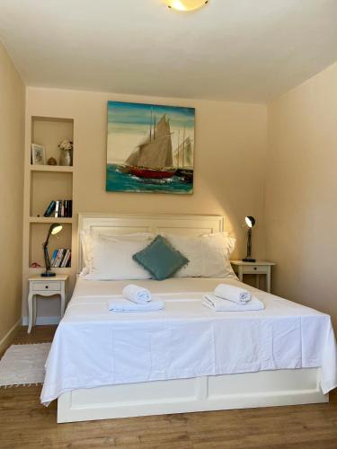 a bedroom with a white bed with two towels on it at Apartment with Sunset terrace in Mlini
