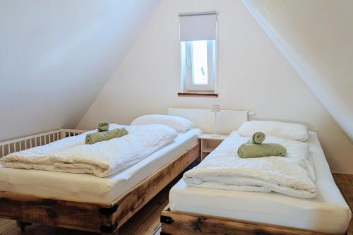 two twin beds in a attic room with a window at Villa Sand in Bad Emstal