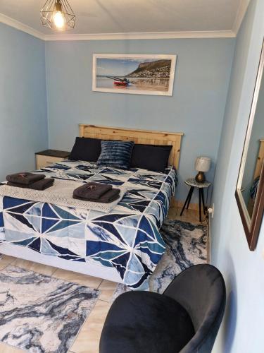 a bedroom with a bed and two chairs at 77 on First! in Fish Hoek