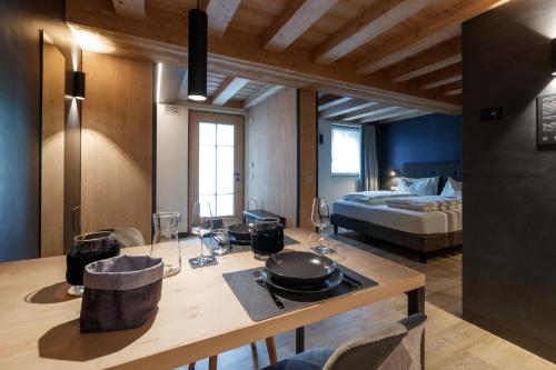 a room with a kitchen with a bed and a table at Wind Villa Genf Spa - Relax in Livigno
