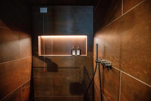 a bathroom with a shower with two bottles on it at Wind Villa Genf Spa - Relax in Livigno