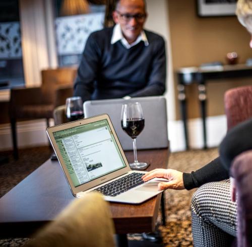 a group of people sitting around a table with a laptop at York House Hotel in Whitley Bay