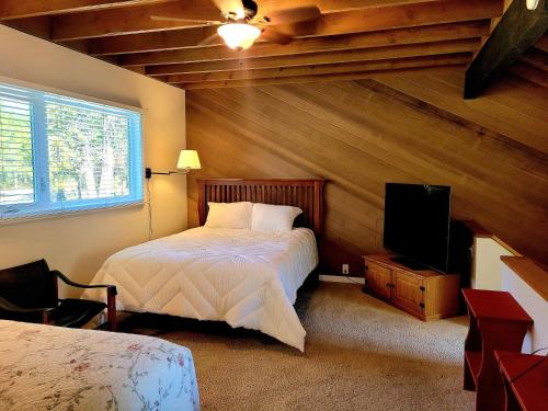 a bedroom with a bed and a flat screen tv at 74 Meadow House in Sunriver