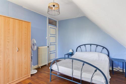 a bedroom with a bed with a blue wall at Gîte Le Trotteur in Monteaux