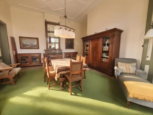 a dining room with a table and chairs and a couch at Huize Beukenstein in Lochem