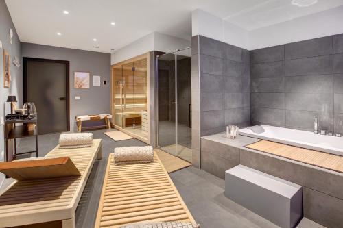 a bathroom with a tub and a shower and a sink at Spark Chalet e Spa Livigno in Livigno