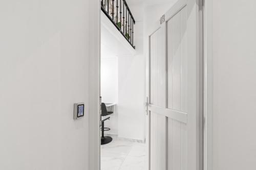 a white hallway with a door and a desk at Vima Lofts in Torrevieja
