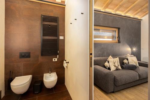 a living room with a couch and a toilet at Chalet River Villa Genf Spa - Relax in Livigno