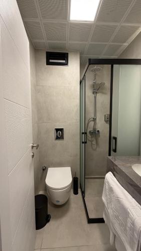ein Badezimmer mit Dusche, Toilette und Waschbecken in der Unterkunft Rıdvan Hotel in Cesme
