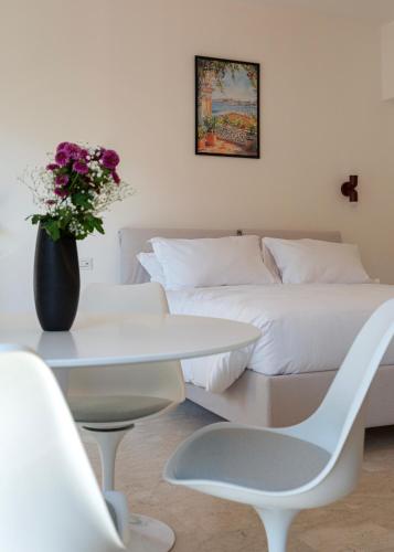 a living room with a bed and a table with a vase of flowers at La Farmacia in Stresa