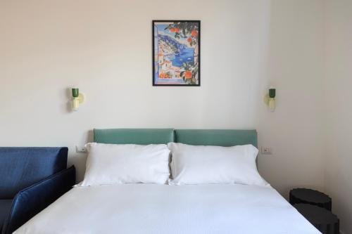 a bed with two pillows and a picture on the wall at La Farmacia in Stresa