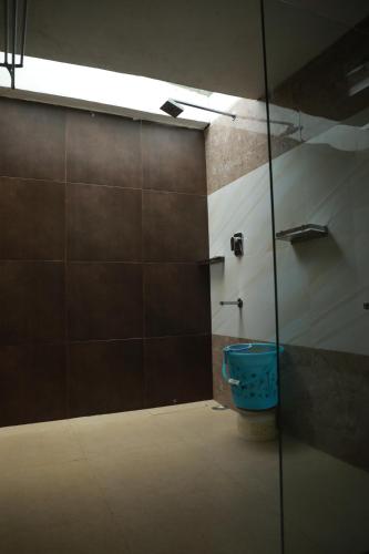 a bathroom with a glass shower with a toilet at The Den by Trees in Kotagiri