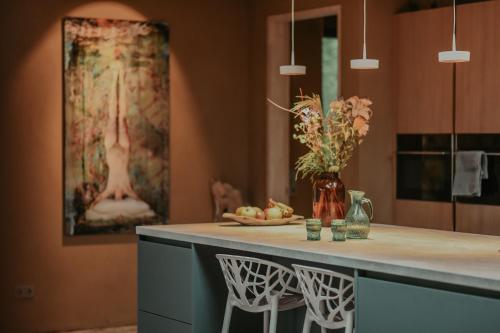 a kitchen with a counter with a vase of flowers at Huis De Mijmering in Heikant