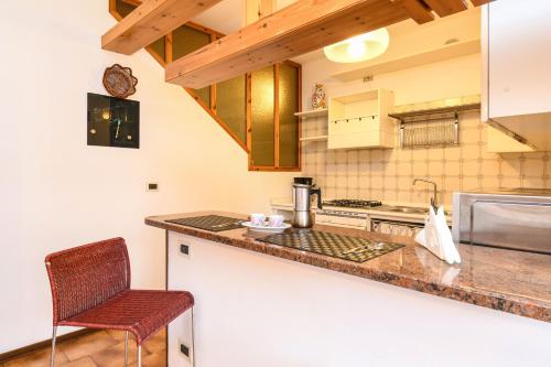a kitchen with a counter and a chair in it at Civic 55 in Toscolano Maderno