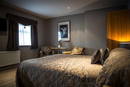 a hotel room with a bed and a chair at York House Hotel in Whitley Bay