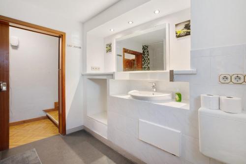 a white bathroom with a sink and a mirror at Knödelhof in Putzbrunn