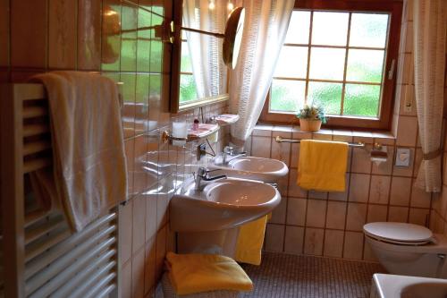 a bathroom with two sinks and a toilet and a window at Haus Bachschwalbe in Sasbachwalden