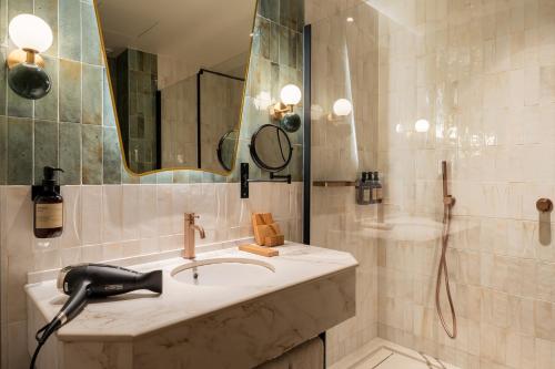 a bathroom with a sink and a mirror and a shower at Hotel Condal in Barcelona
