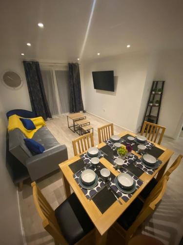a dining room with a table and a couch at 3BR House in Harlow, Essex in Great Parndon