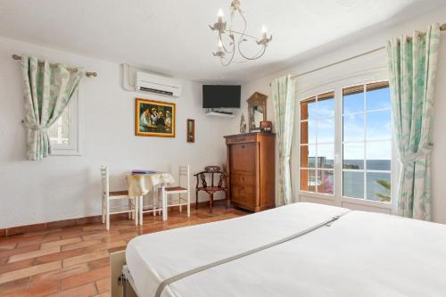 a bedroom with a bed and a table and a window at Studio Palmeraie in Saint-Raphaël