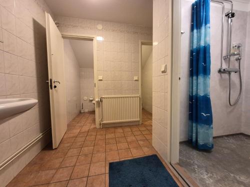 a bathroom with a shower with a blue shower curtain at Granbergs Gästhem in Eckerö