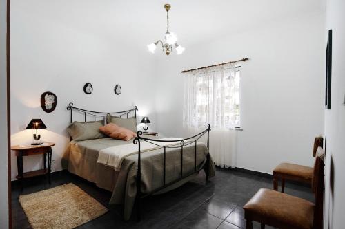a bedroom with a bed and a window at Casa das Hortênsias in Raminho