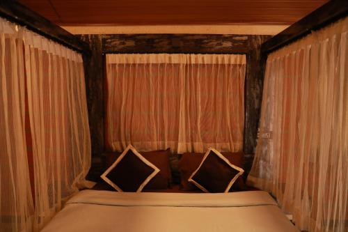 a bed in a room with curtains and a bed sidx sidx sidx at The Den by Trees in Kotagiri