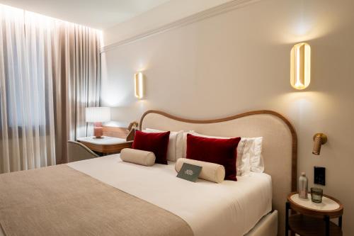 a hotel room with a large bed with red pillows at Hotel Condal in Barcelona