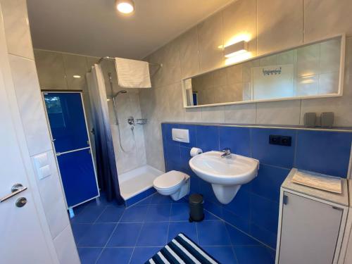 a blue bathroom with a toilet and a sink at Sonnenhang in Sigmarszell