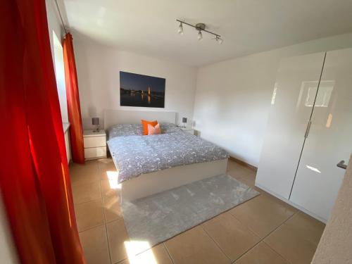 a bedroom with a bed with an orange pillow at Sonnenhang in Sigmarszell