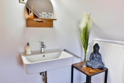 a bathroom with a sink and a statue on a table at Bordmann` Scheune in Kolonie
