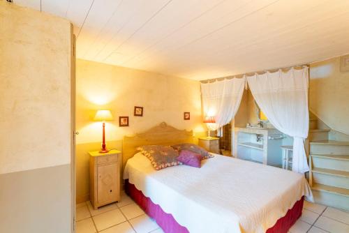 a bedroom with a large bed and a window at Le Patio in Velleron