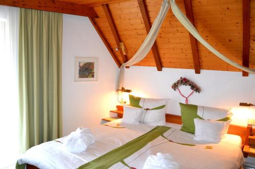 a bedroom with a bed with white sheets and wooden ceilings at Haus Bachschwalbe in Sasbachwalden