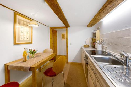 a kitchen with a sink and a wooden table at Ferienwohnung Gartenfreude in Veckenstedt