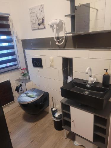 a bathroom with a black sink and a toilet at Ferienhaus Schw Agnes in Warin