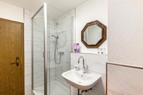 a white bathroom with a sink and a shower at Fewo45 in Homberg