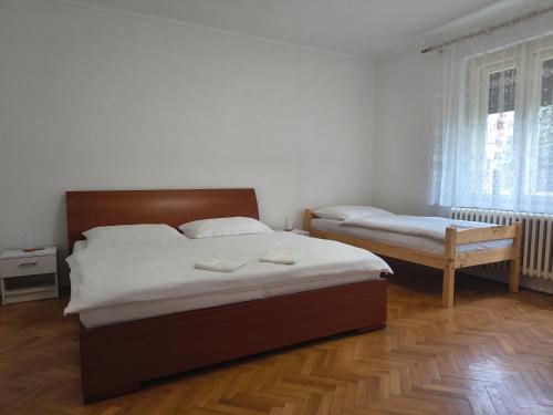 a bedroom with two beds and a table and window at Vidiecky Dom in Mojmírovce