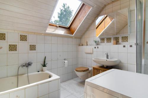 a bathroom with a tub and a sink and a toilet at Jogis Paradies In Ruhiger Lage in Stockach