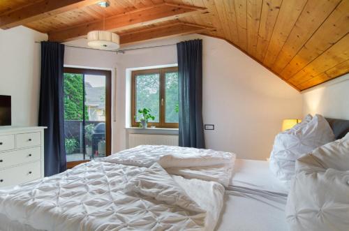 a bedroom with a white bed with a wooden ceiling at Jogis Paradies In Ruhiger Lage in Stockach